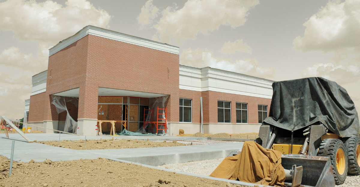 Adult hand holding a child's hand, symbolizing care. Skin tones vary, setting appears to be indoors with blurred background.