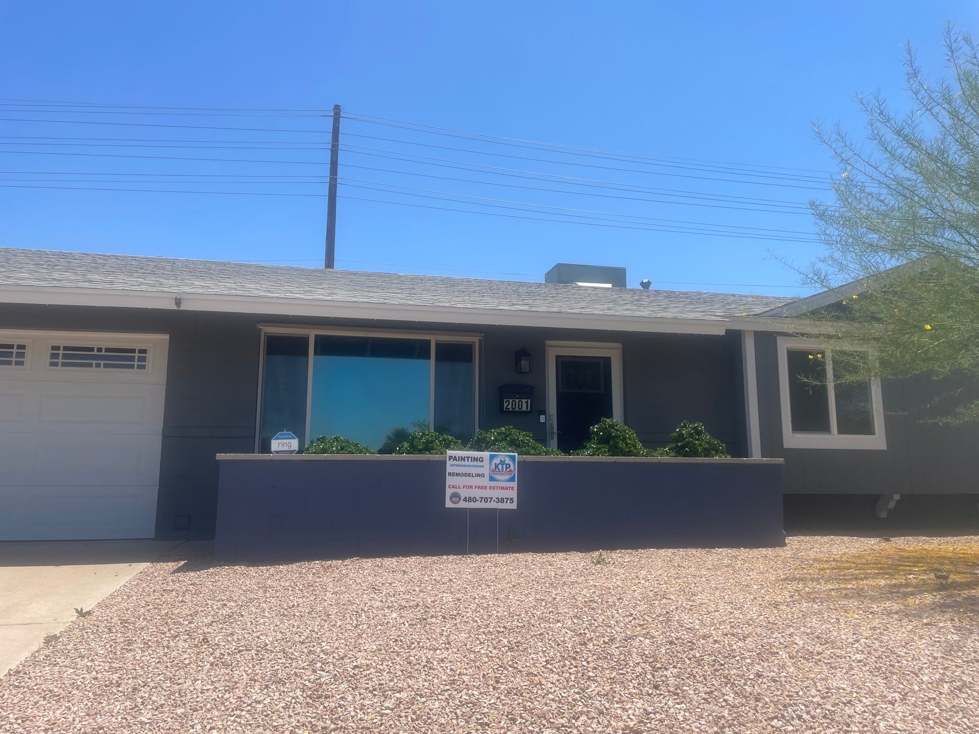 A house with a garage and a sign in front of it.