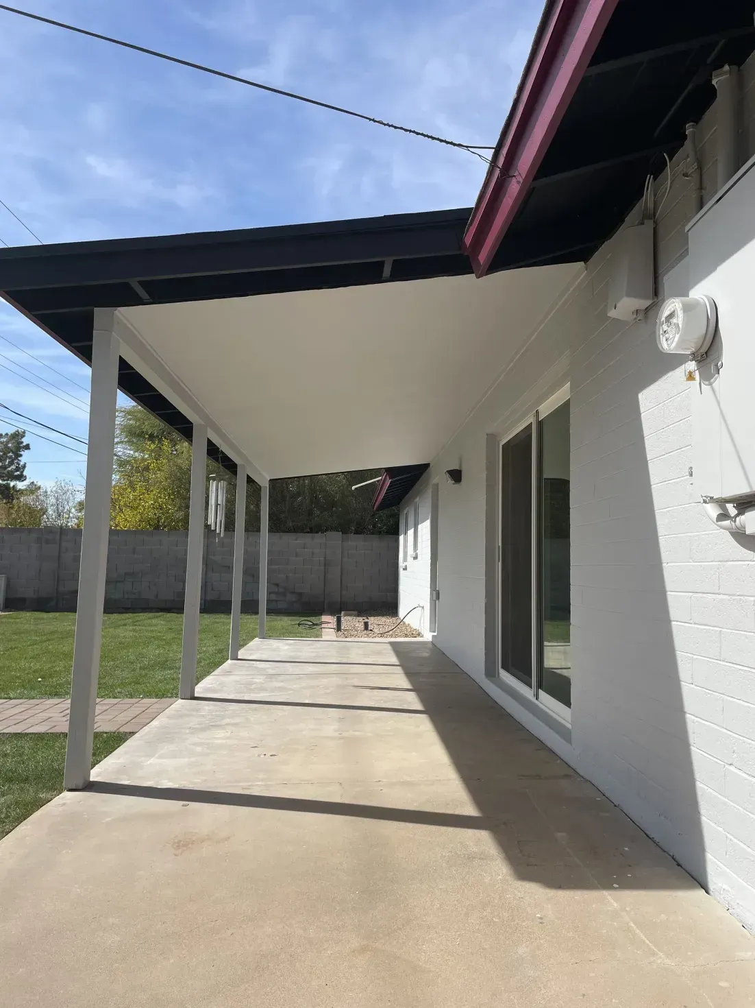 A white house with a porch and sliding glass doors