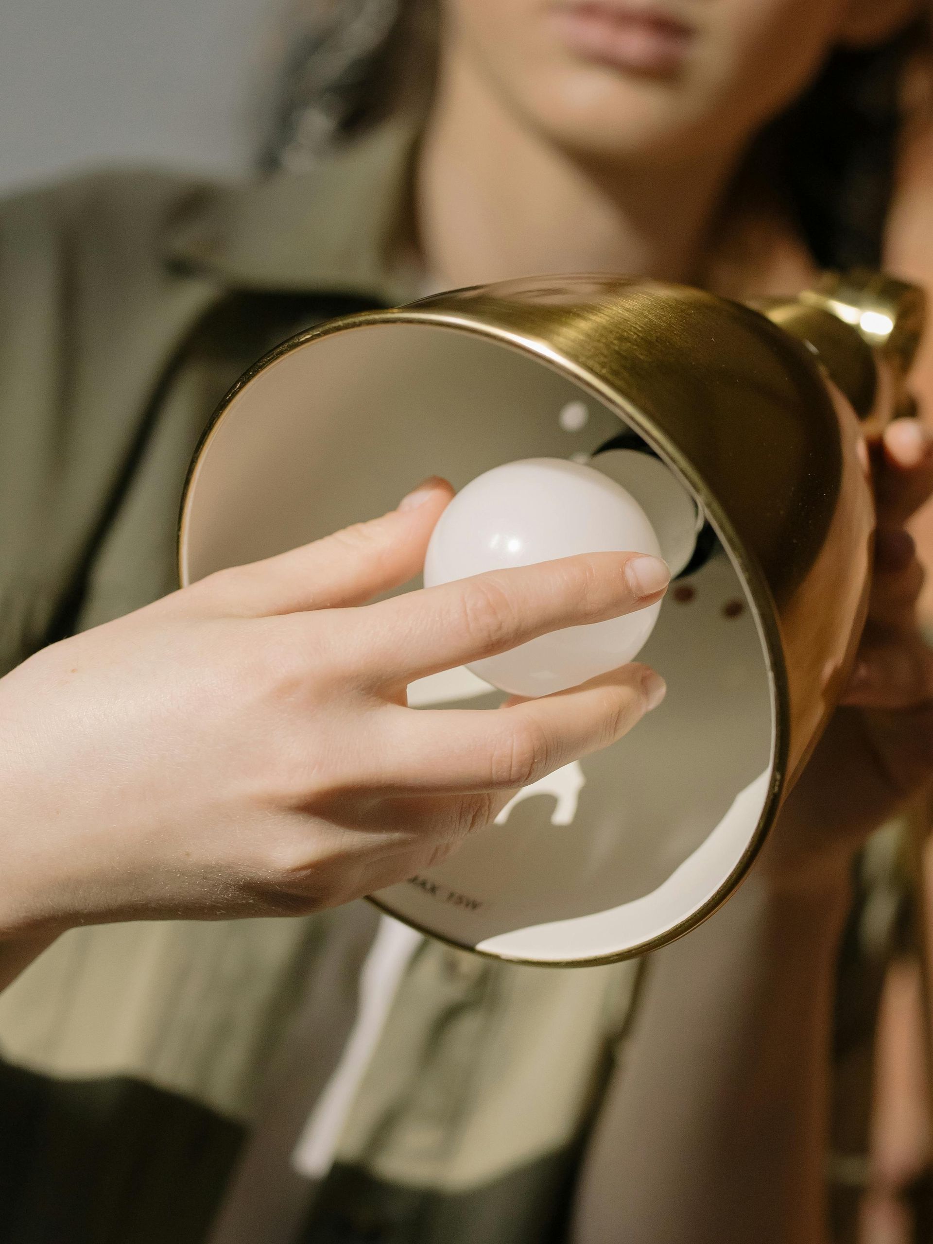 A woman is holding a light bulb in her hand.