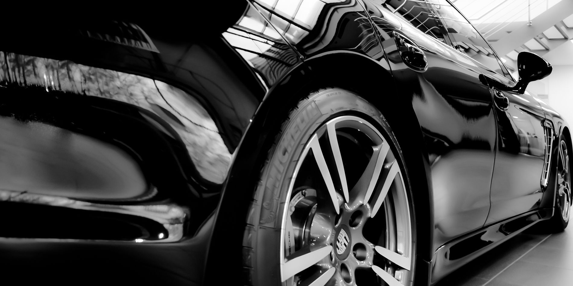 A black and white photo of a car in a showroom.