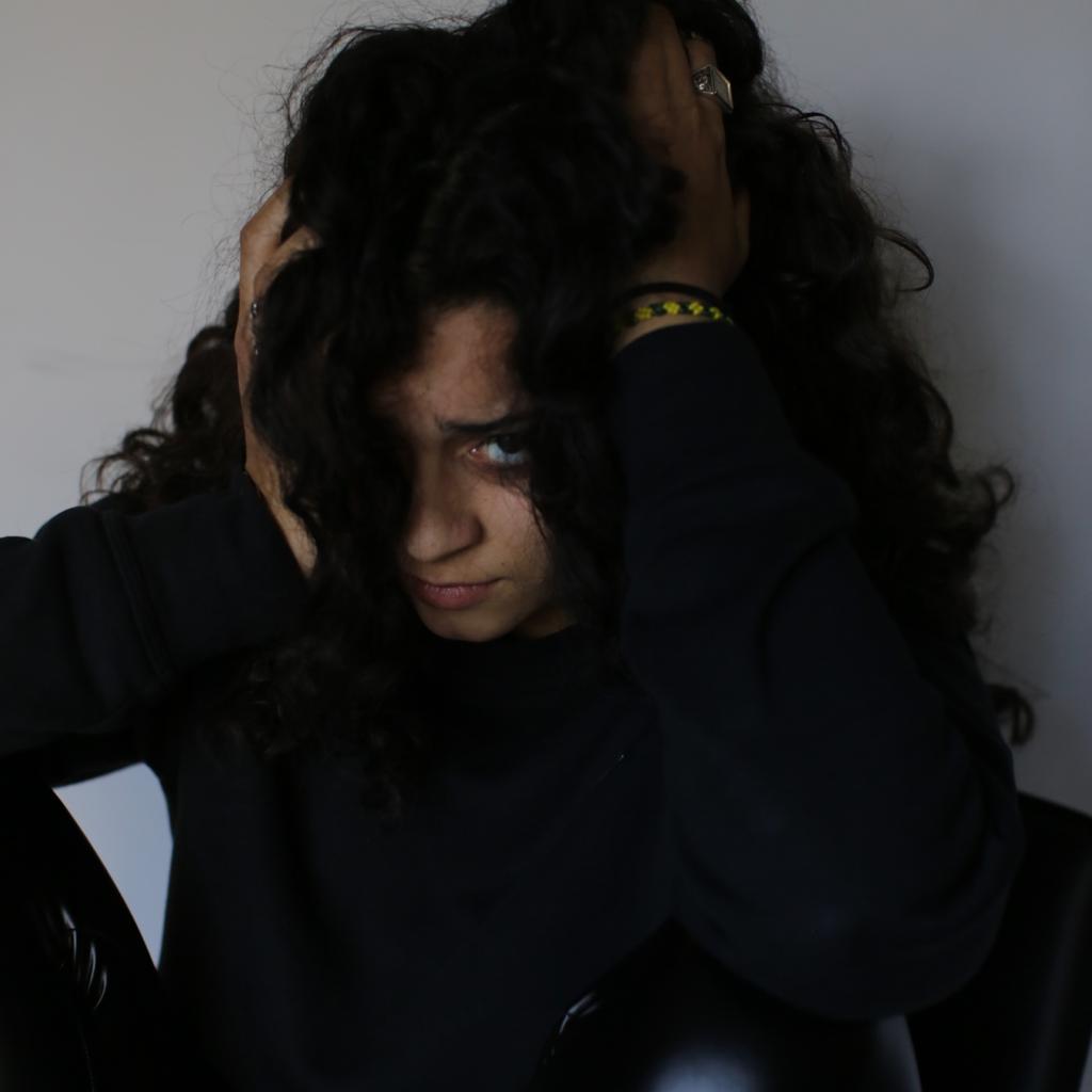 Donna preoccupata con mani fra i capelli