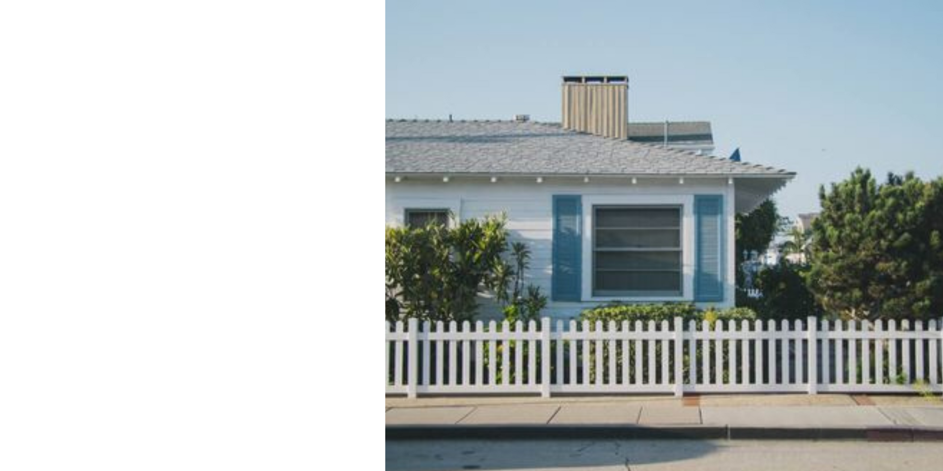 A white house with a white picket fence in front of it.