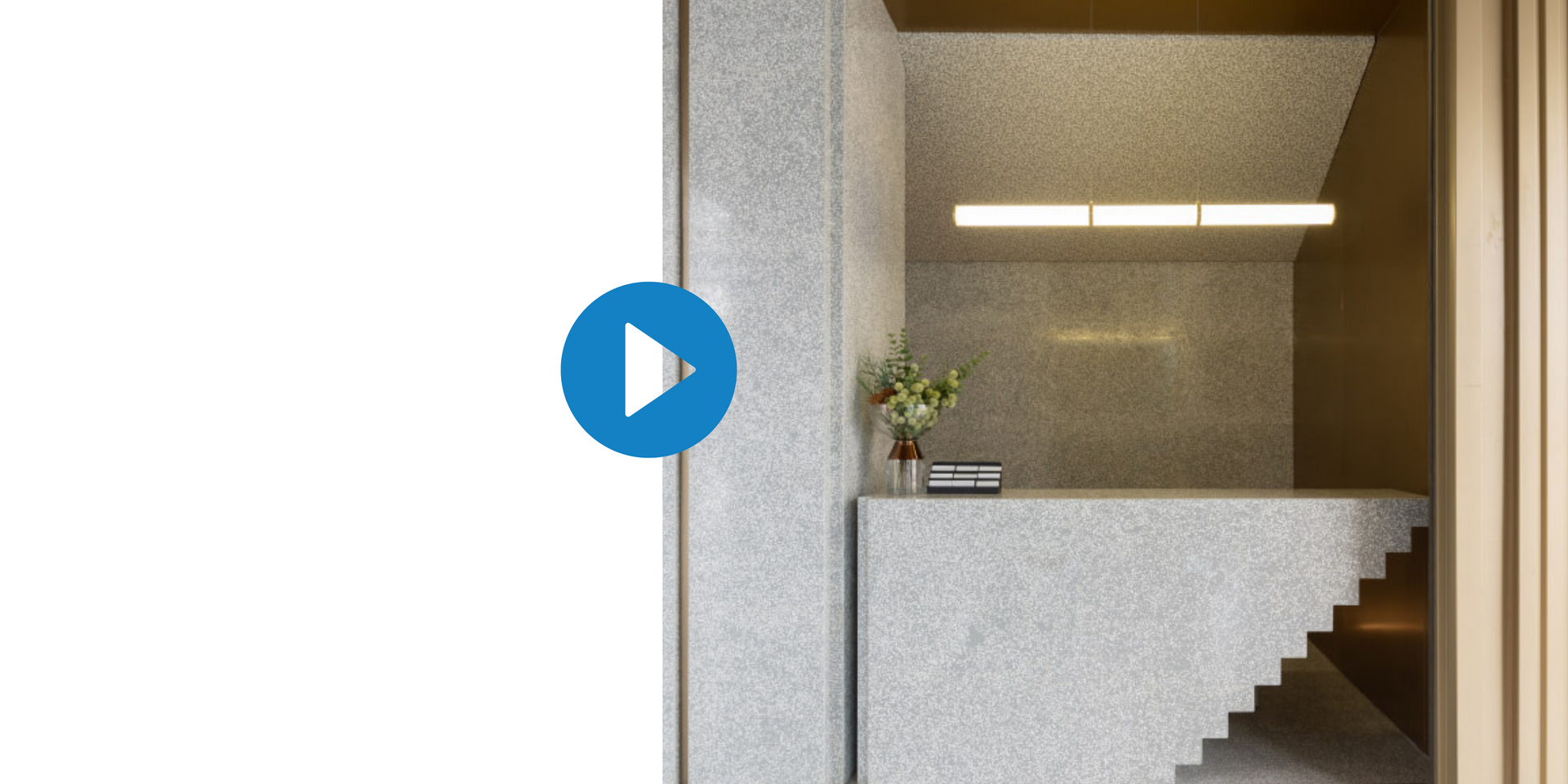 A video of a reception area with stairs and a play button.