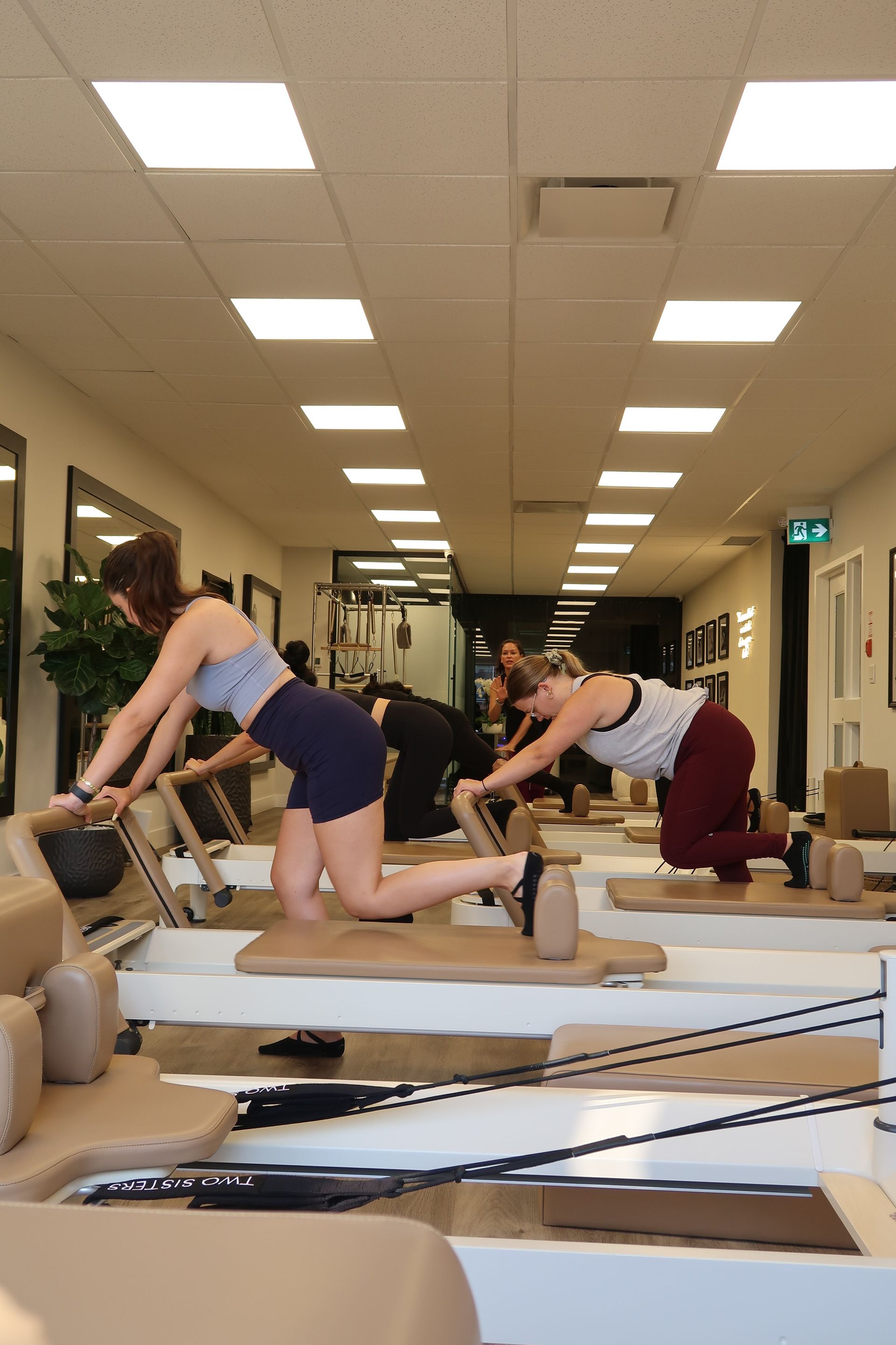 Group Reformer Pilates class in Oakville with women performing controlled lower body and core exercises