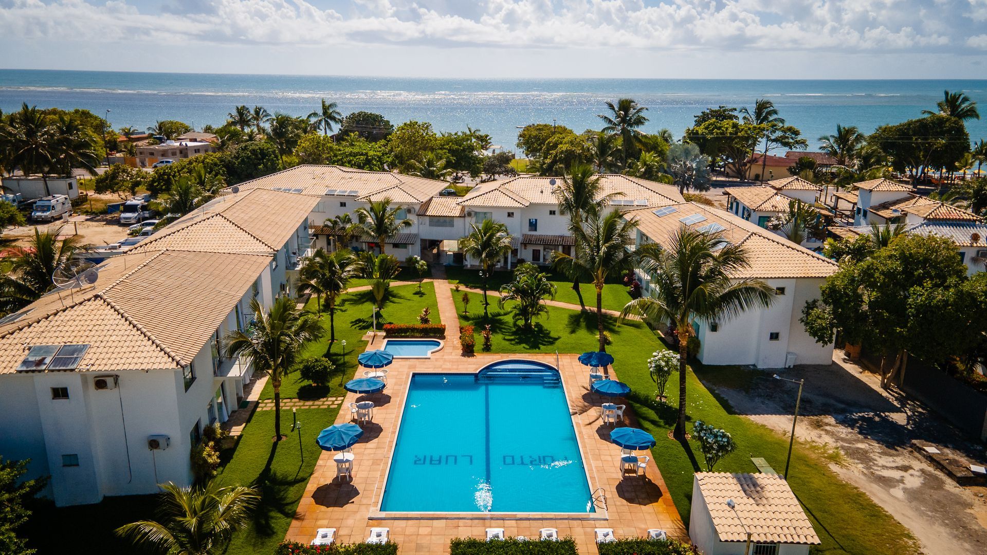Uma vista aérea de um hotel com uma grande piscina no meio. Hotel-Porto-Luar