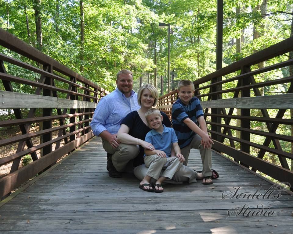 A family posing for a picture on a wooden bridge
