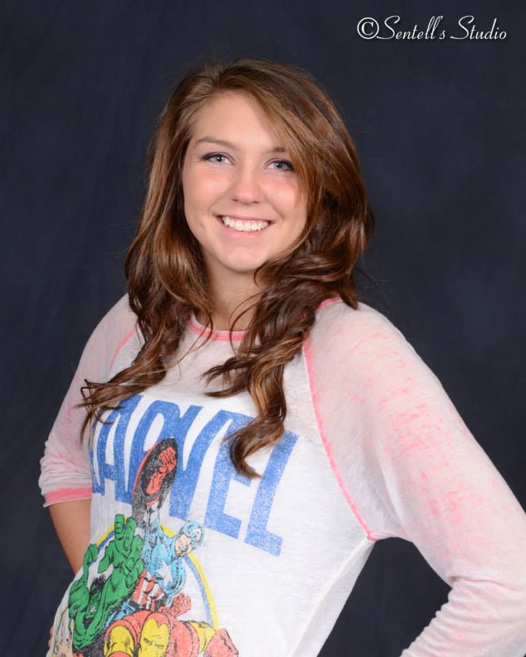A woman wearing a marvel shirt smiles for the camera