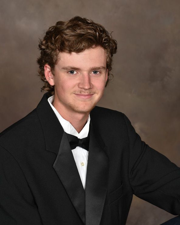 A young man wearing a tuxedo and bow tie