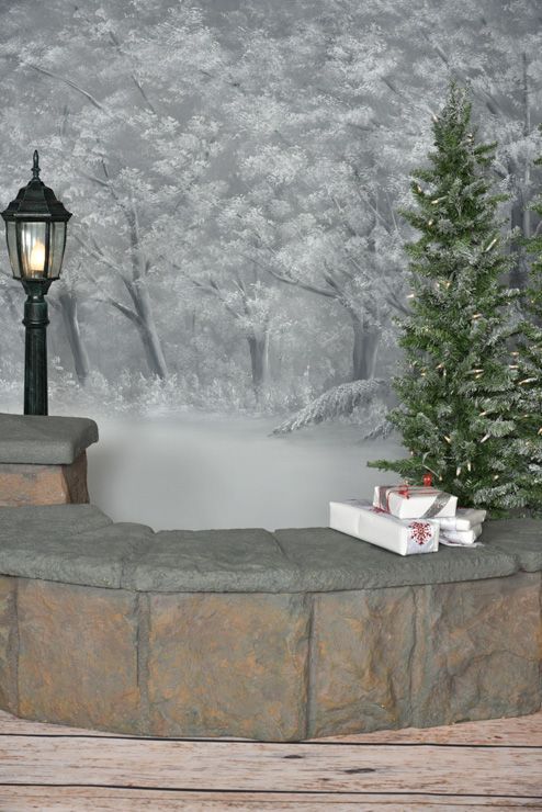 A christmas tree is sitting on a bench next to a lamp post.