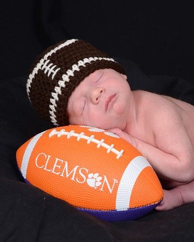 A baby is sleeping on a clemson football