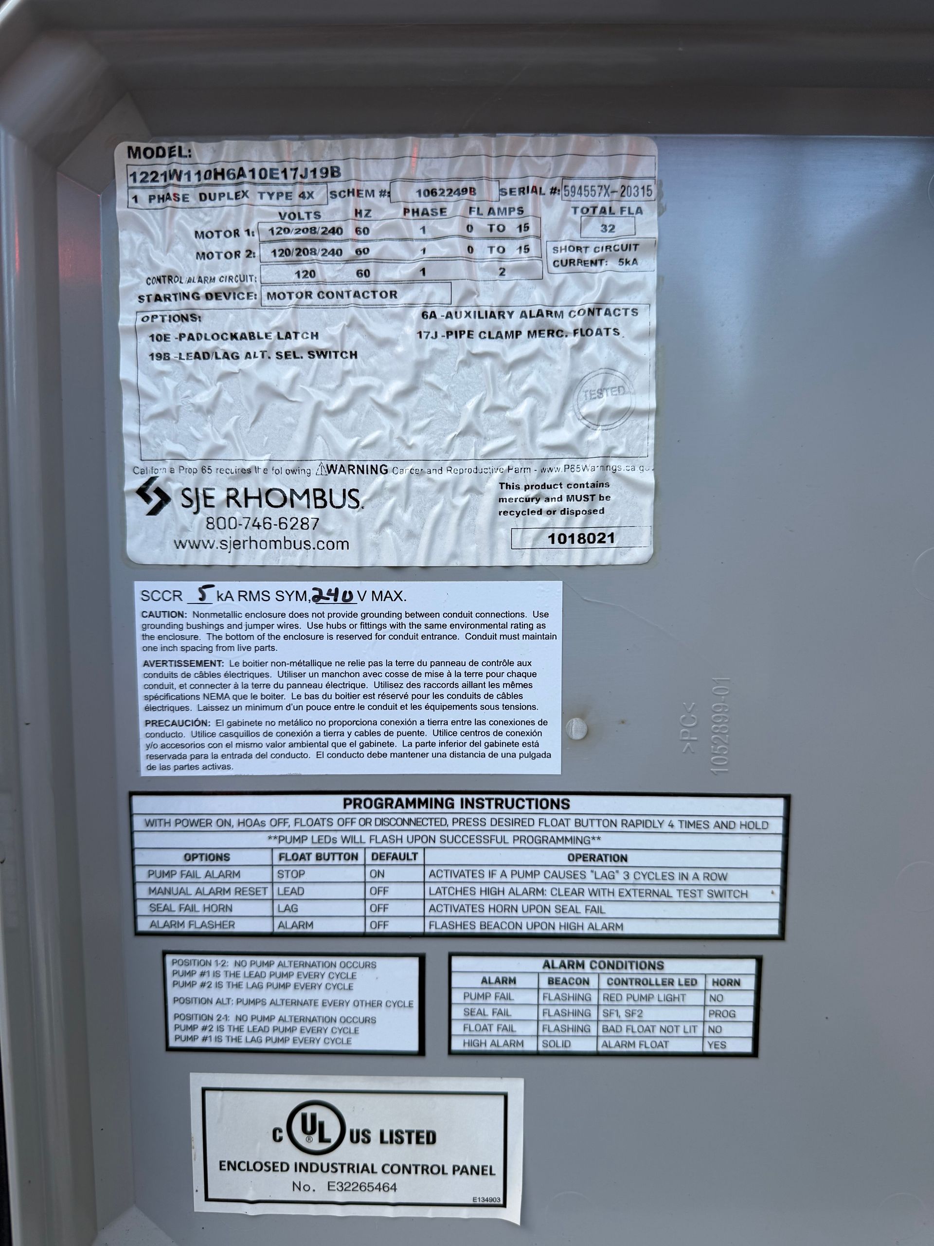 The nameplate of an HVAC unit showing technical specifications, model number, and safety compliance labels.