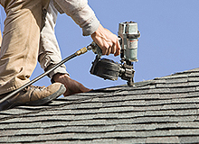 Roofer Nailing Cap to House Roof