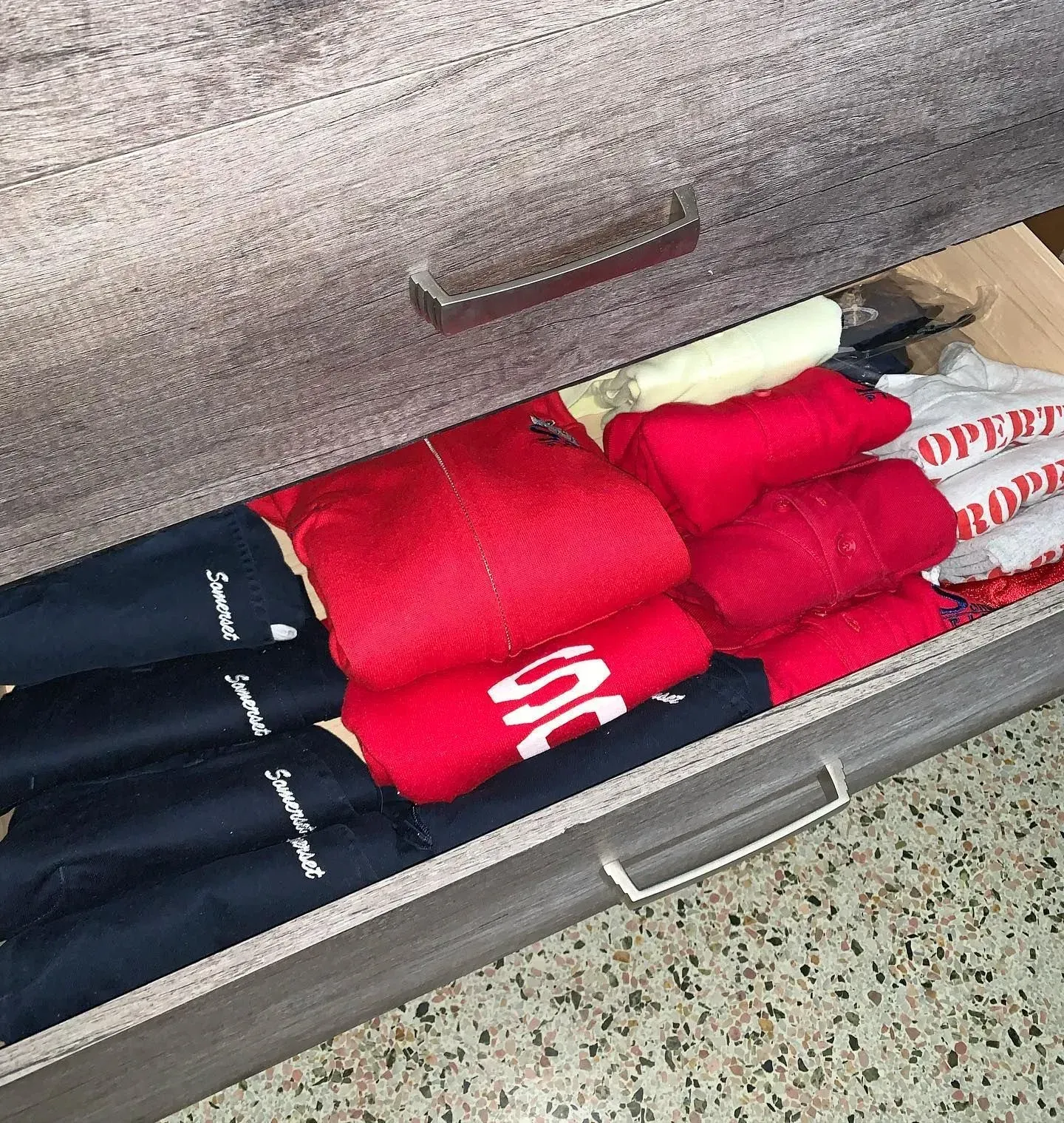 A drawer filled with clothes including a pair of rode socks