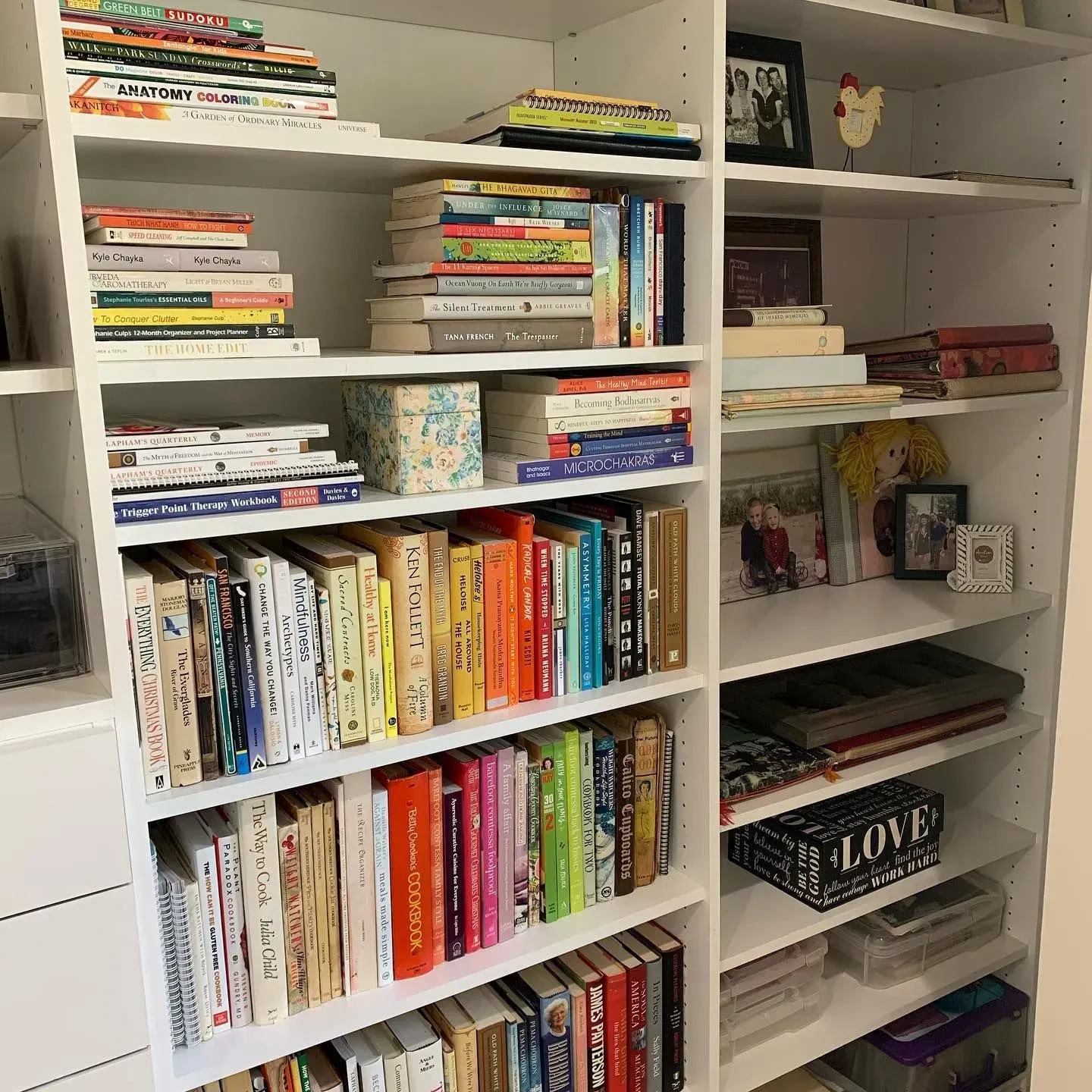 A bookshelf filled with books and a box that says love