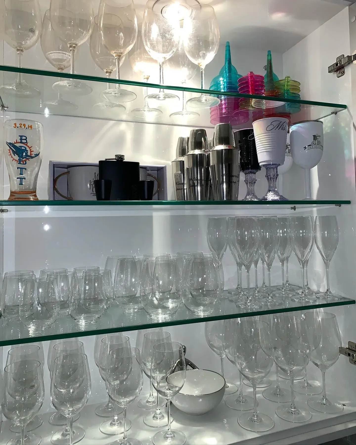 A glass shelf filled with wine glasses and other items
