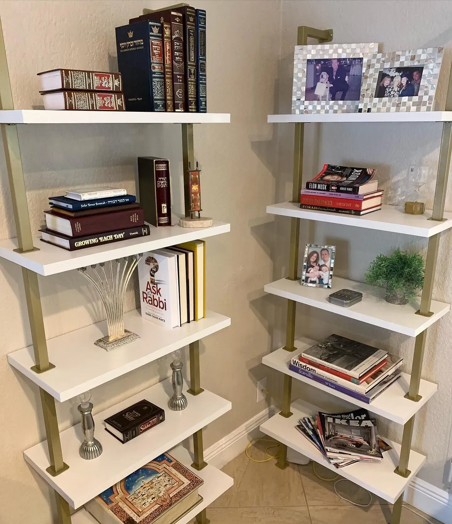Two shelves with books and pictures on them in a room