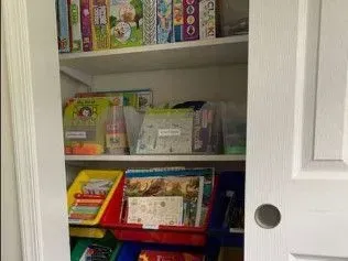 A closet filled with lots of children 's toys and books.