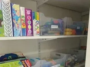 A shelf filled with lots of toys and books.