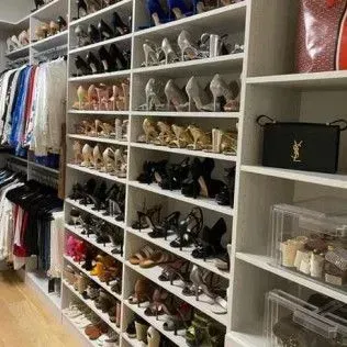 A closet filled with lots of shoes and bags.