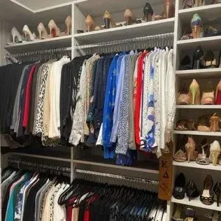 A closet filled with lots of clothes and shoes.