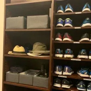 A closet filled with shoes , hats , and boxes.
