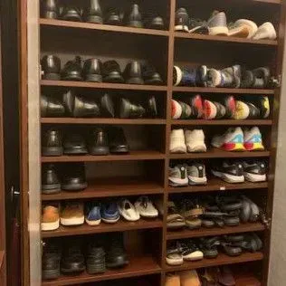A closet filled with lots of shoes on shelves.