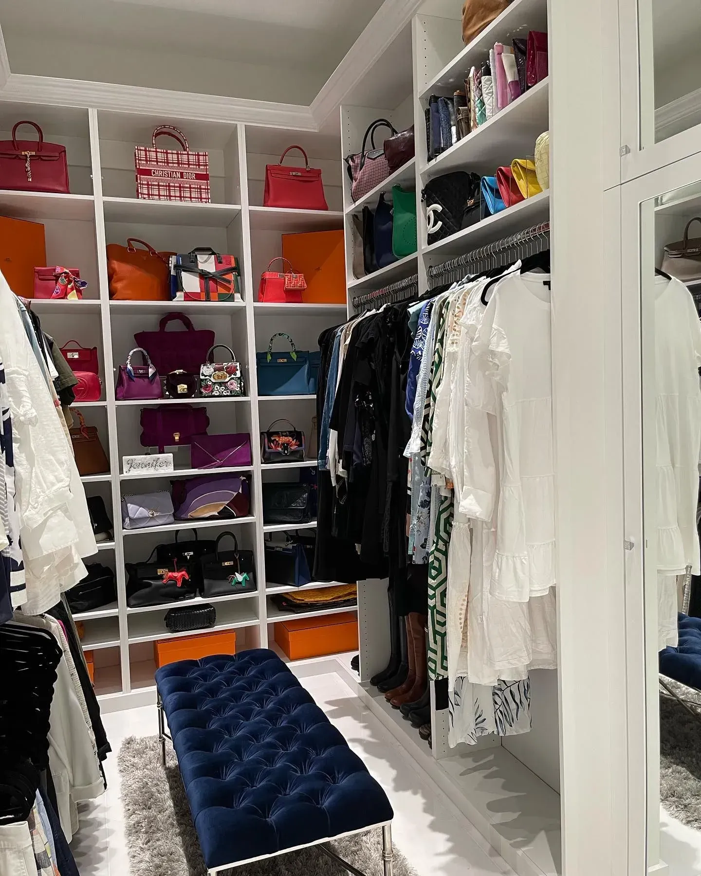 A walk in closet filled with lots of clothes and bags.