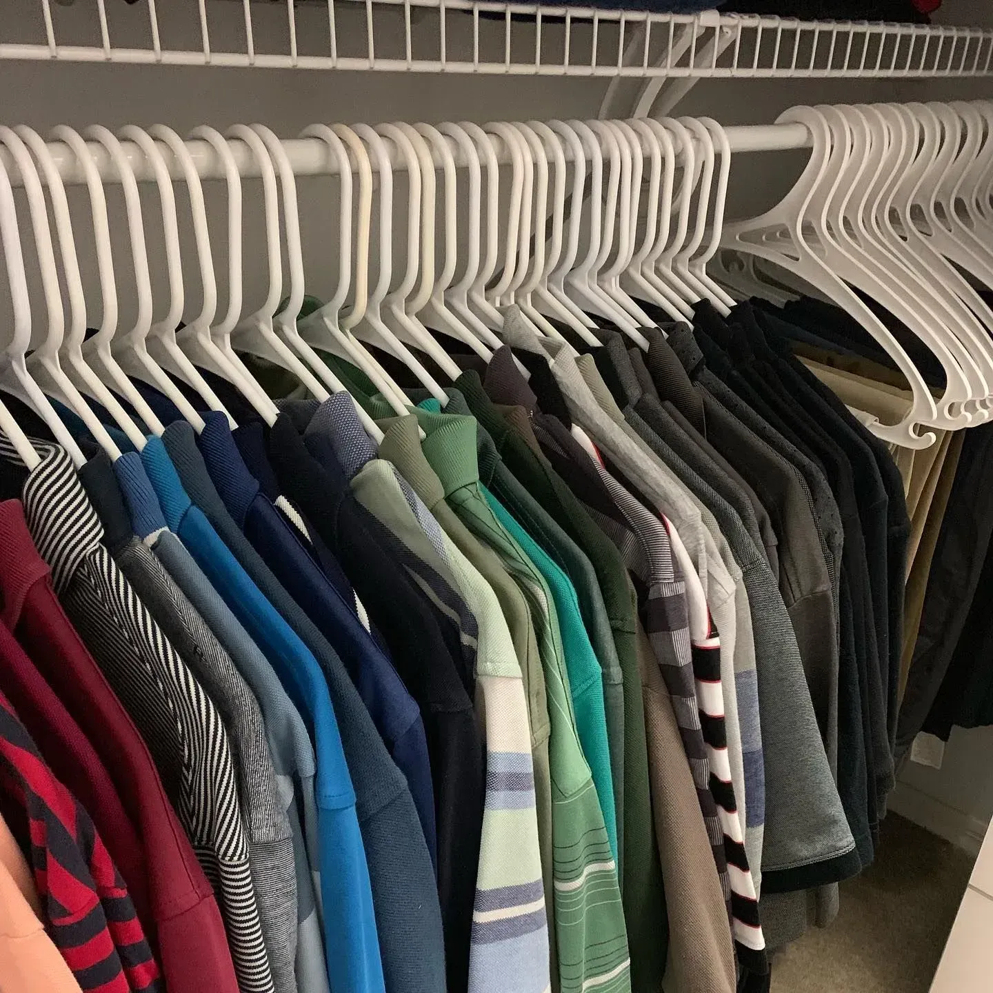 A closet filled with lots of clothes hanging on hangers.