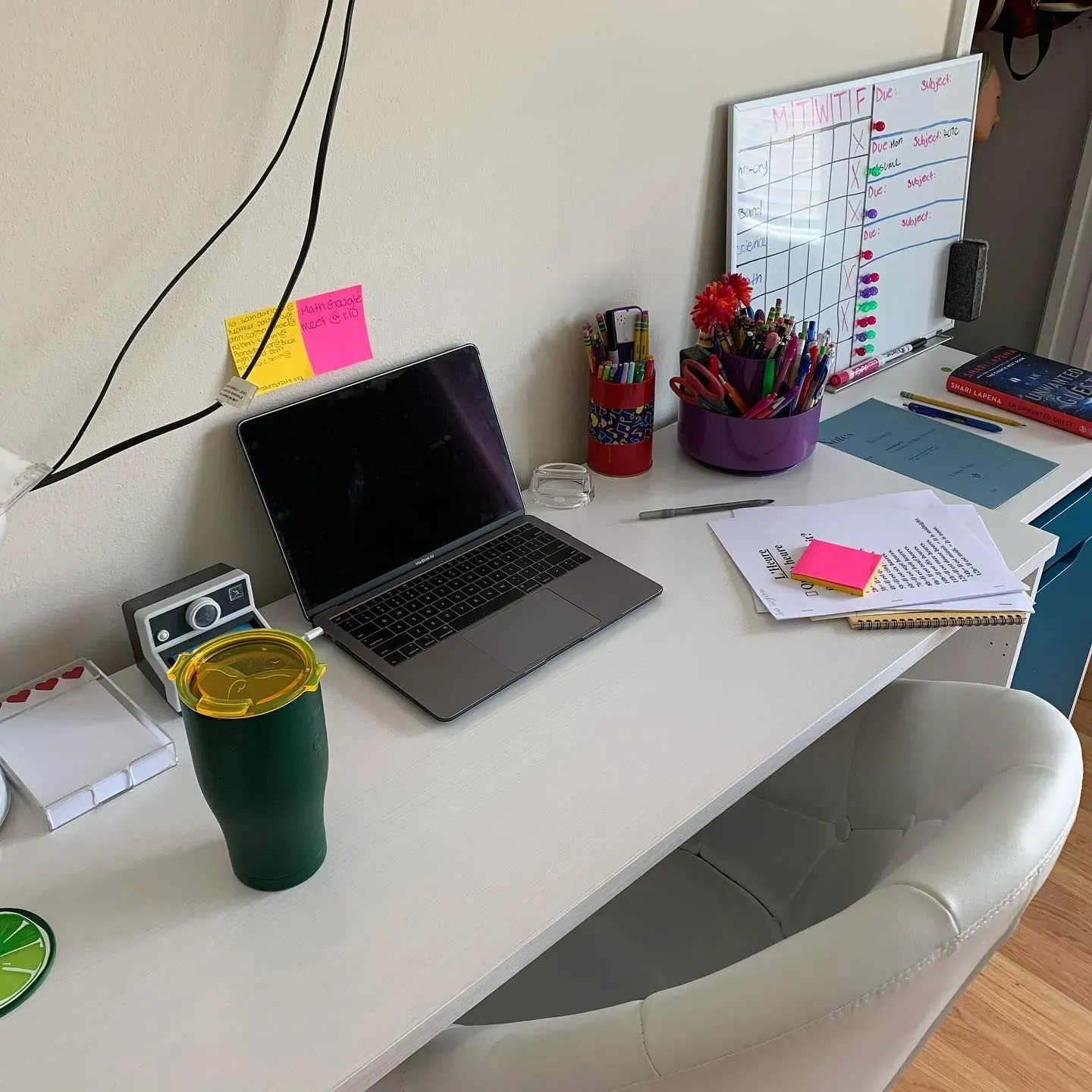 A desk with a laptop and a calendar on it
