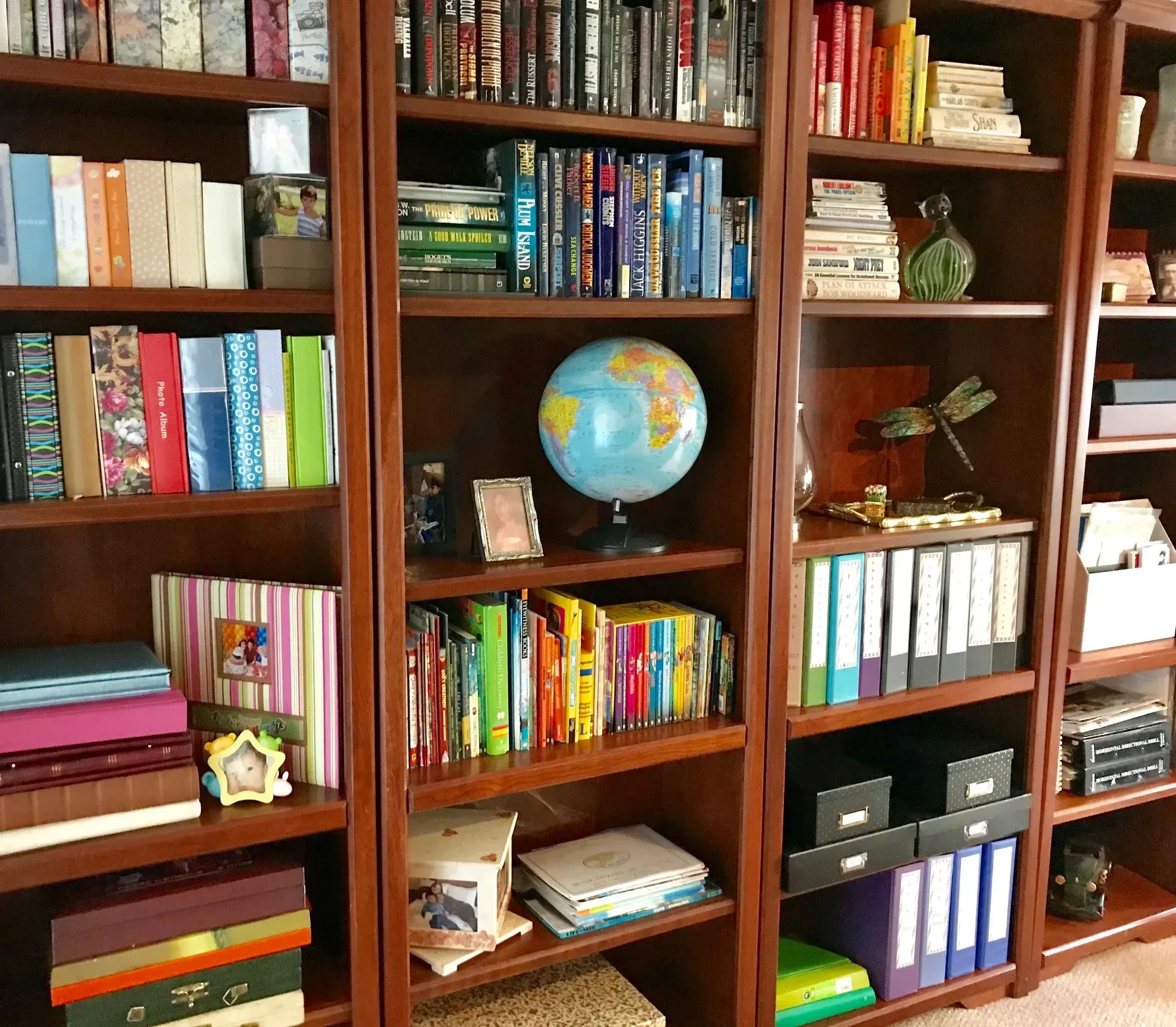 A globe sits on a bookshelf in a library