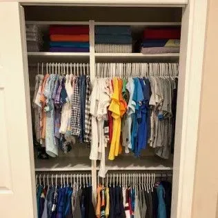 A closet filled with lots of clothes and towels.