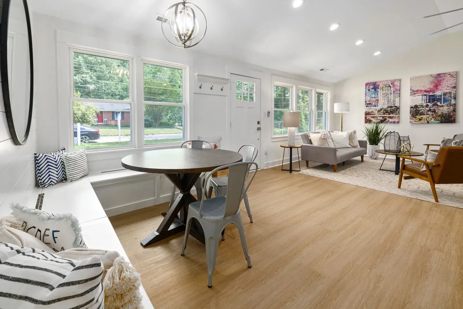 A living room with a table and chairs and a bench.