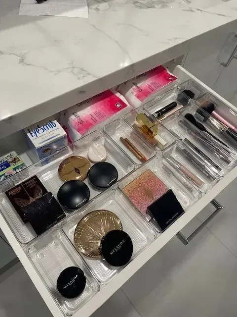 A drawer filled with lots of makeup and brushes.
