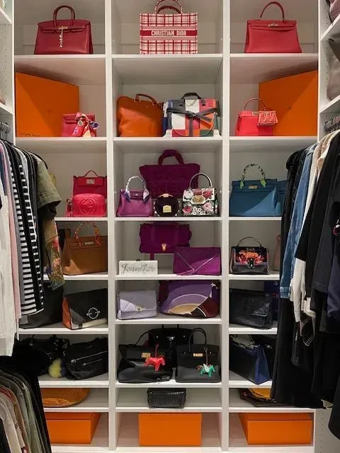 A closet filled with lots of handbags and clothes