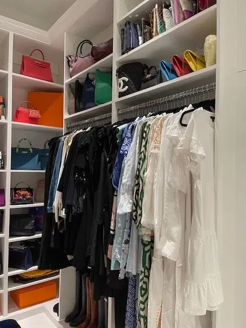 A closet filled with lots of clothes and bags