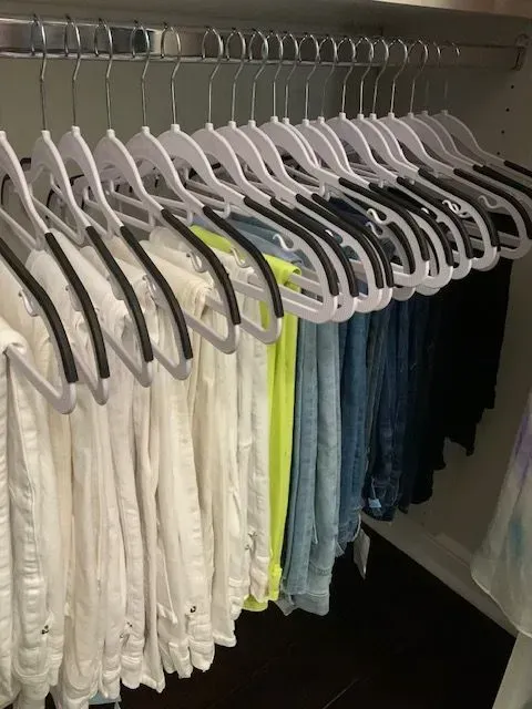 A closet filled with lots of clothes and hangers