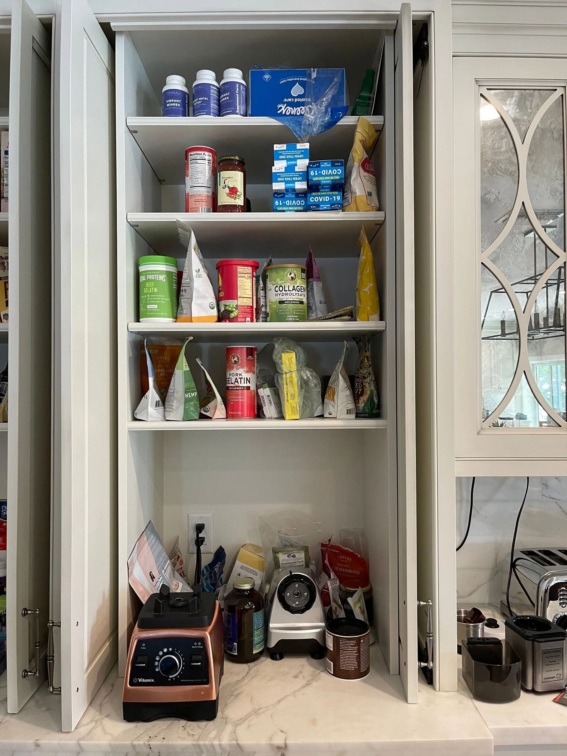A pantry filled with lots of food and a blender.