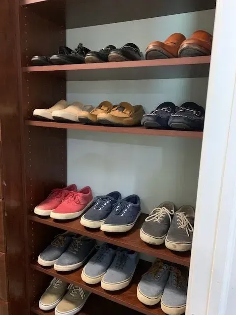 A bunch of shoes are lined up on a shelf