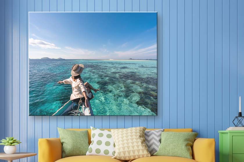 Canvas print on a wall with two people walking on the beach at sunset