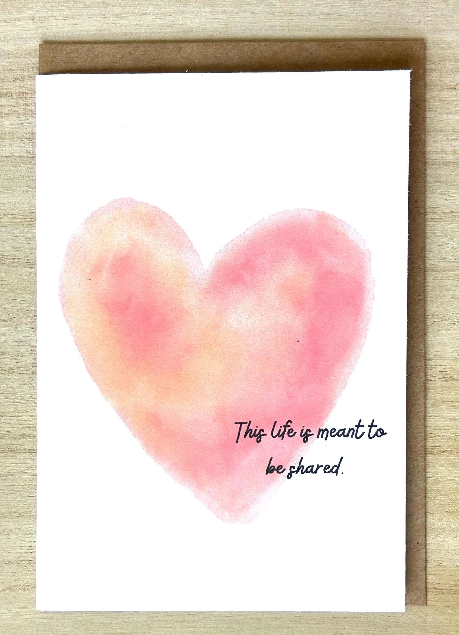 Card with watercolor heart, pink and peach, with text: “This life is meant to be shared.”