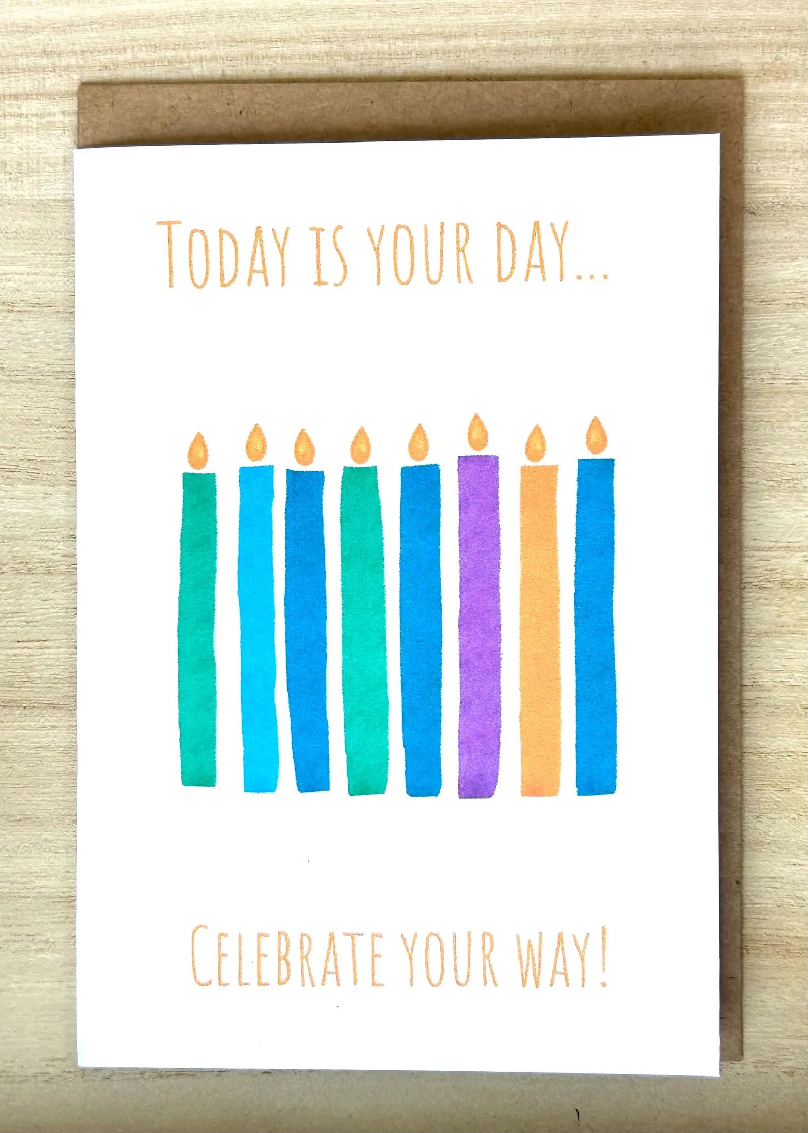 Birthday card with watercolor candles in blue, teal, purple, and orange, with text 