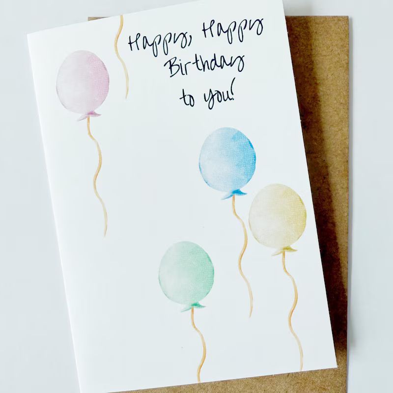 Watercolor birthday card with balloons in pastel colors.