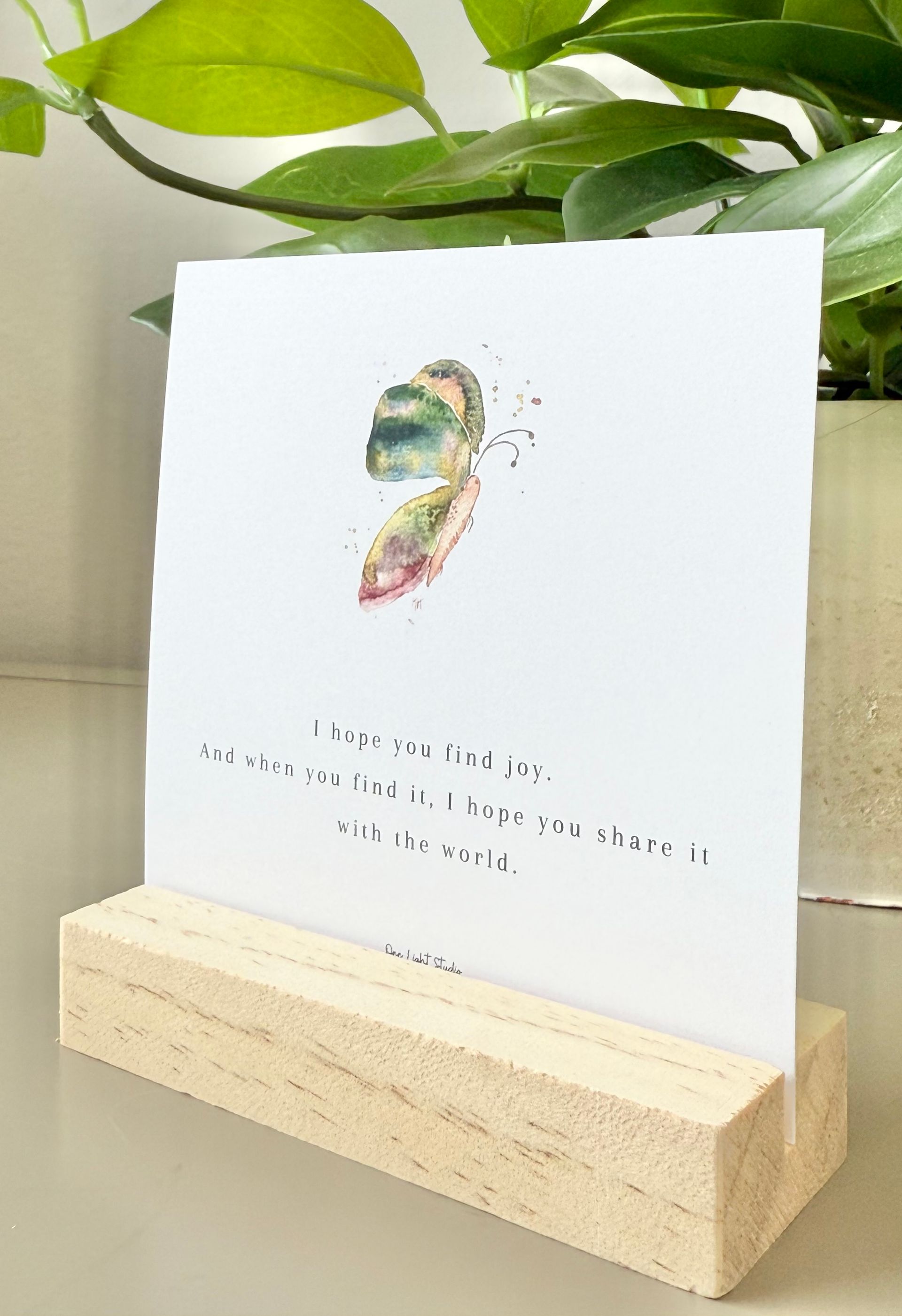 Watercolor snowflake art in a wooden frame, featuring blue and purple hues on a white background.