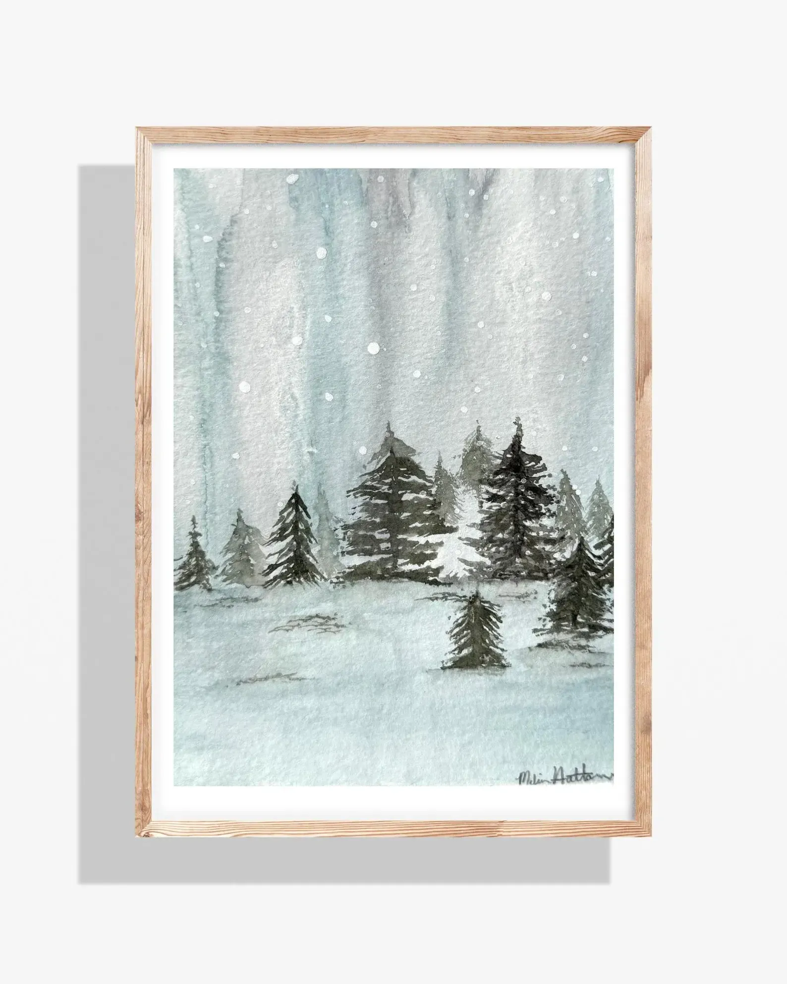 Watercolor painting of snowy forest in a wooden frame. Blue and gray tones; falling snow.