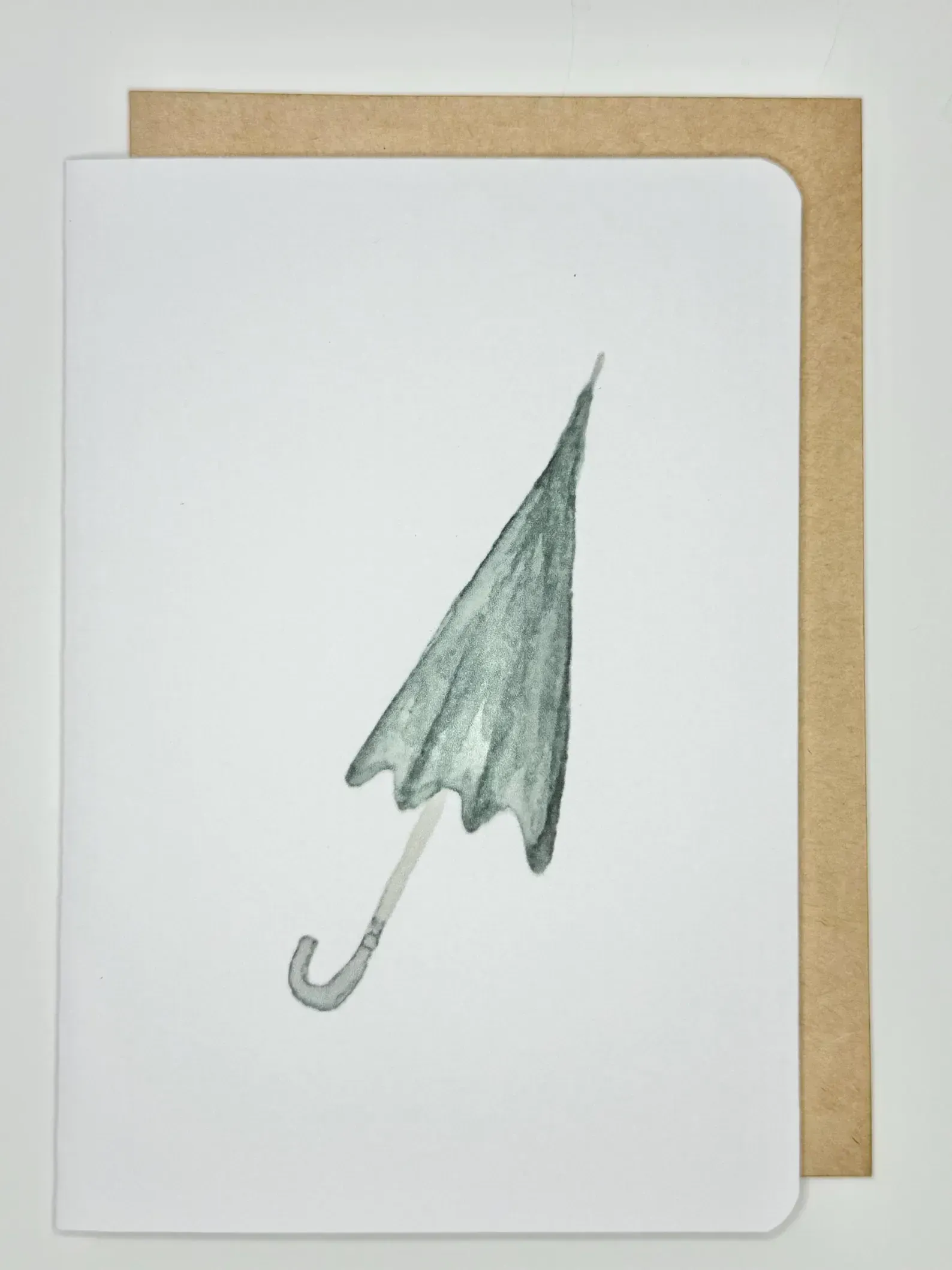 White card with a closed green umbrella, brown envelope.