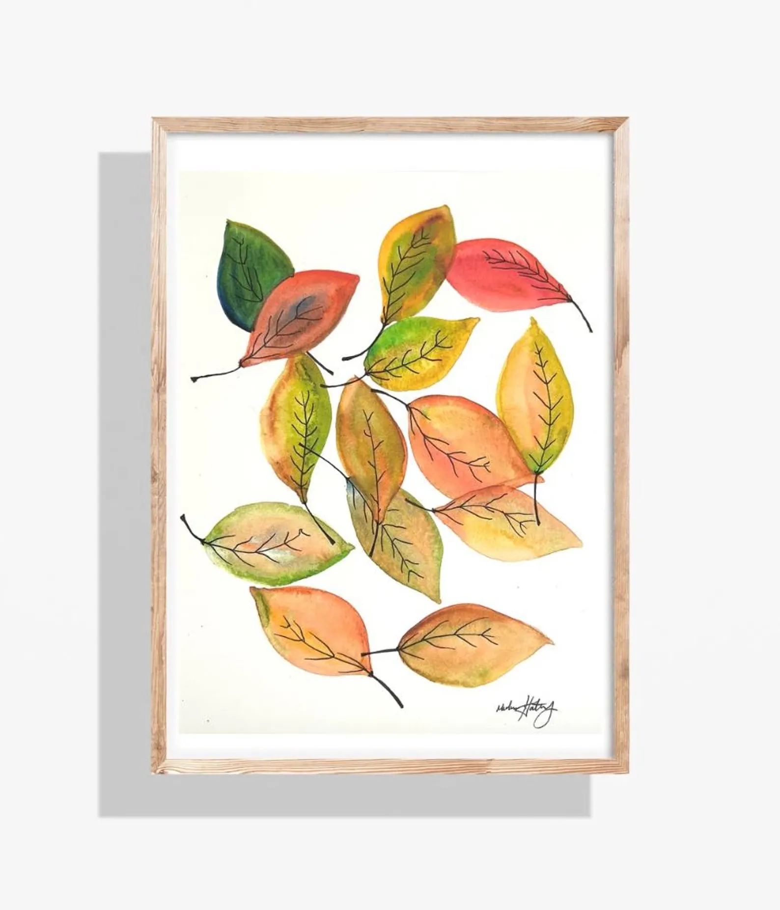Watercolor painting of colorful autumn leaves in a wood frame, against a white background.