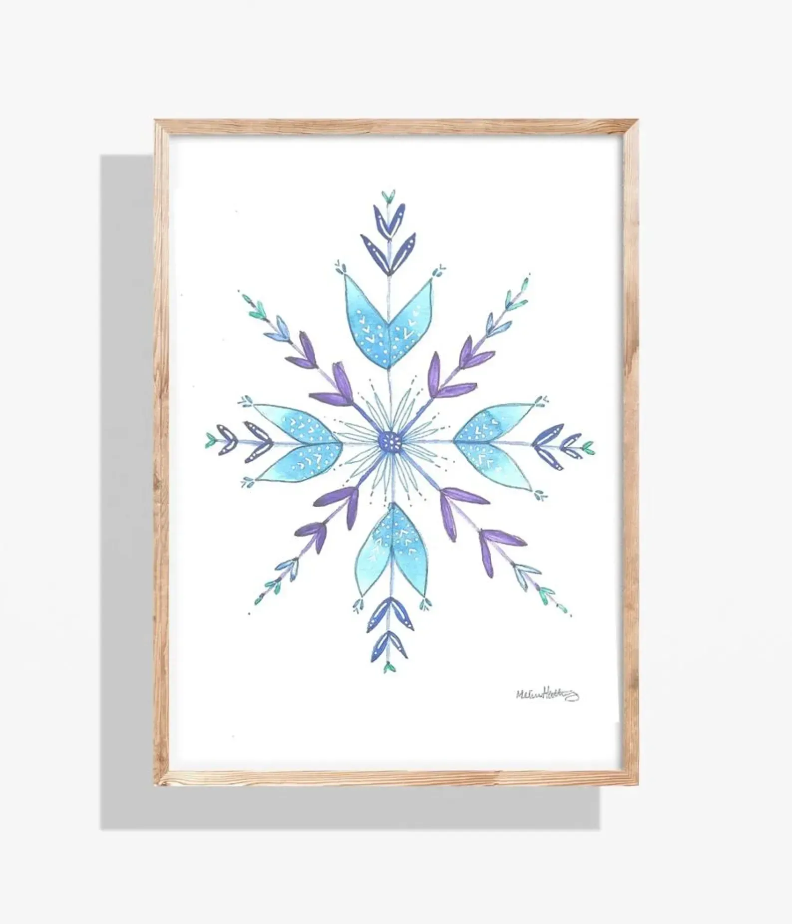 Watercolor snowflake art in a wooden frame, featuring blue and purple hues on a white background.