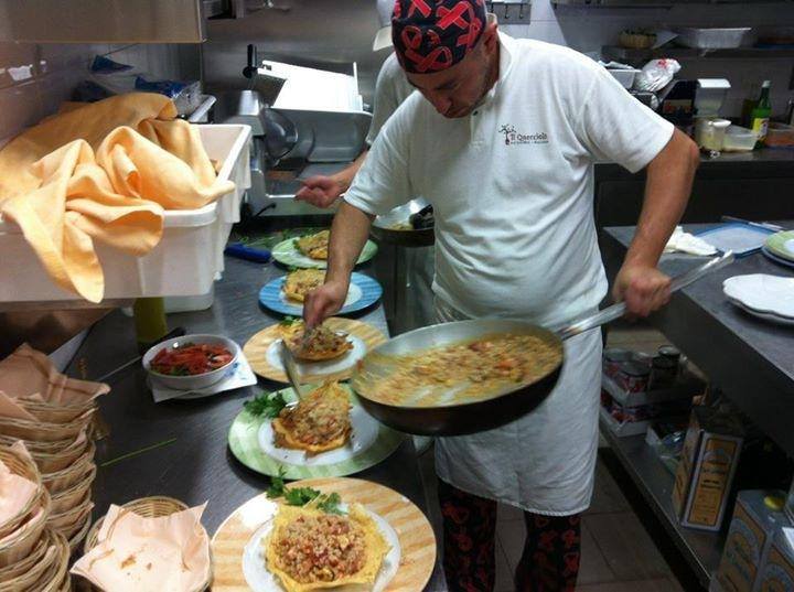 un cuoco che adagia risotto sui piatti