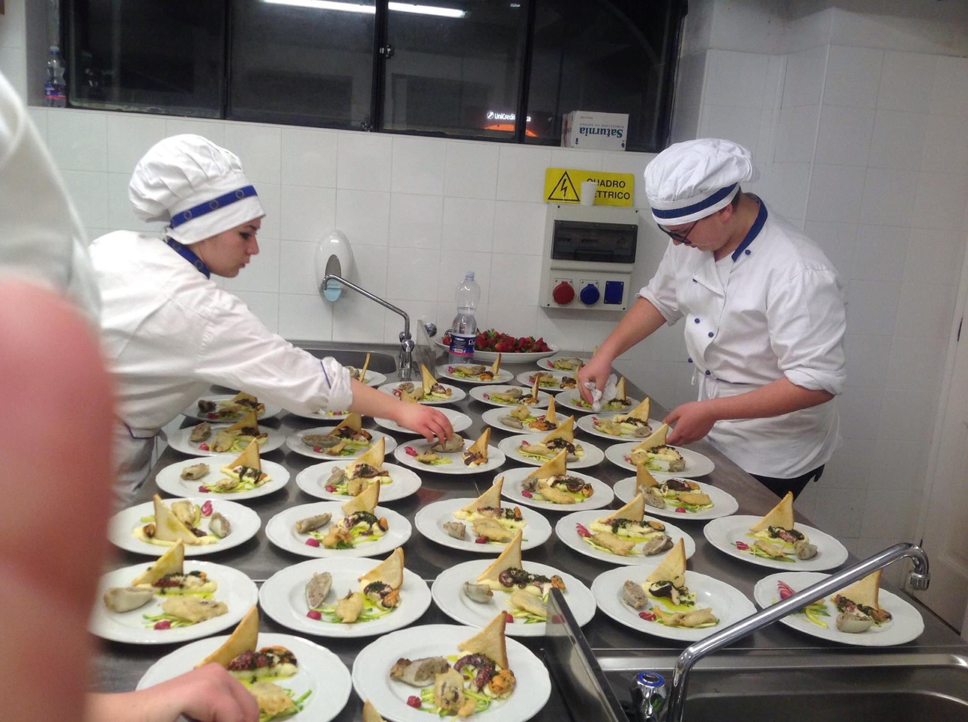 chef che dispongono preparazioni culinarie sui piatti